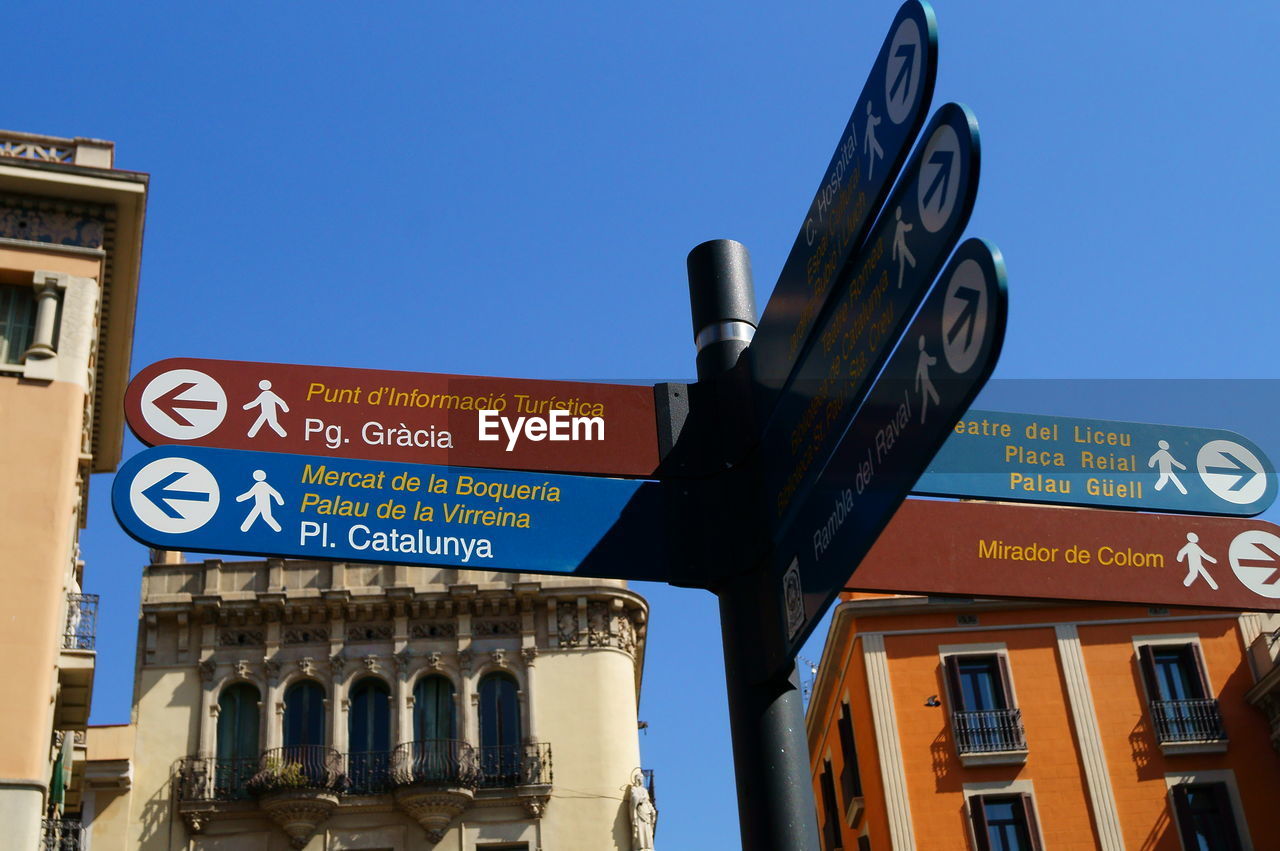 LOW ANGLE VIEW OF ROAD SIGNS AGAINST BLUE SKY