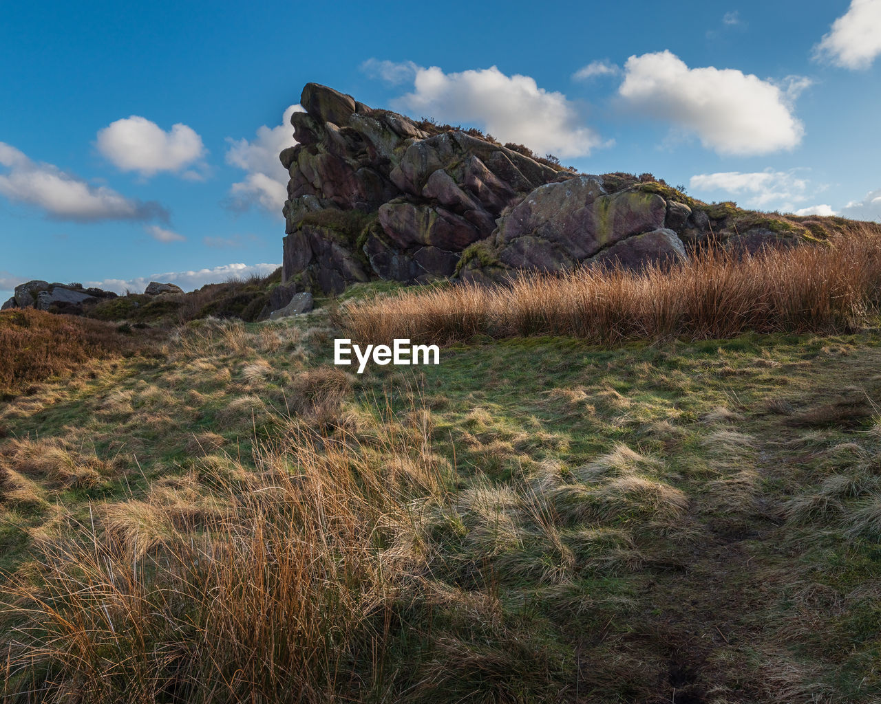 Scenic view of rocks on field against sky