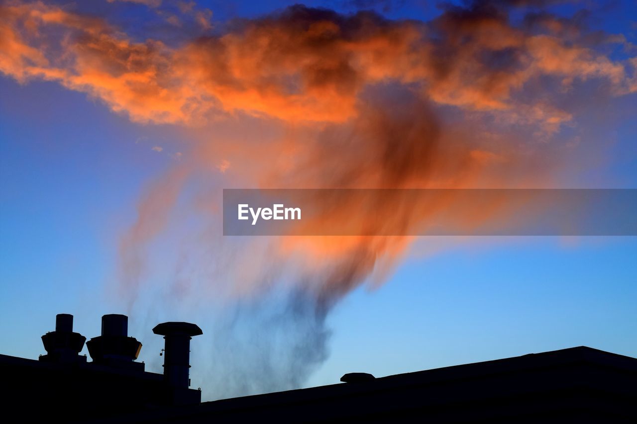 Low angle view of smoke emitting from chimney against sky