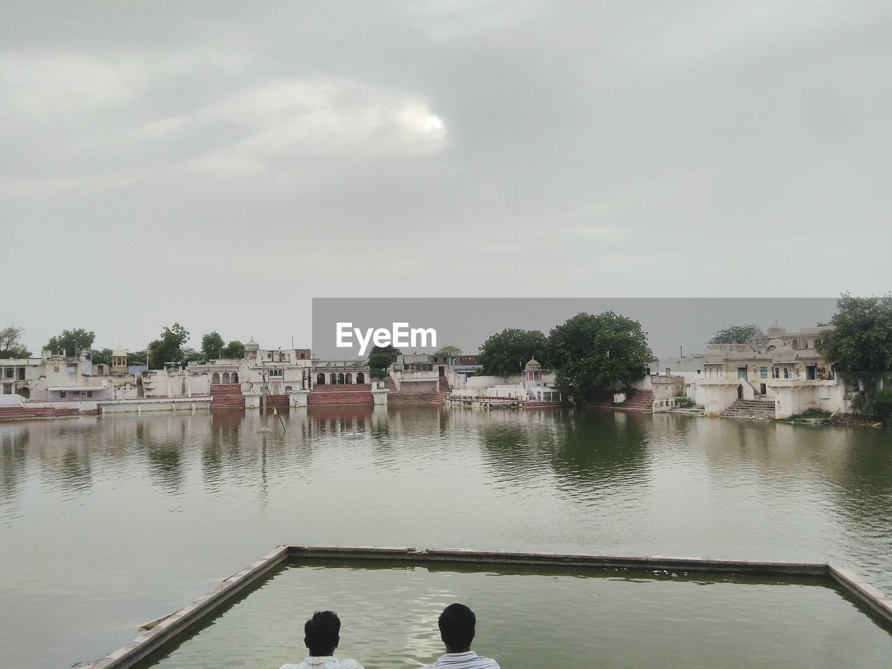 LAKE BY BUILDINGS AGAINST SKY