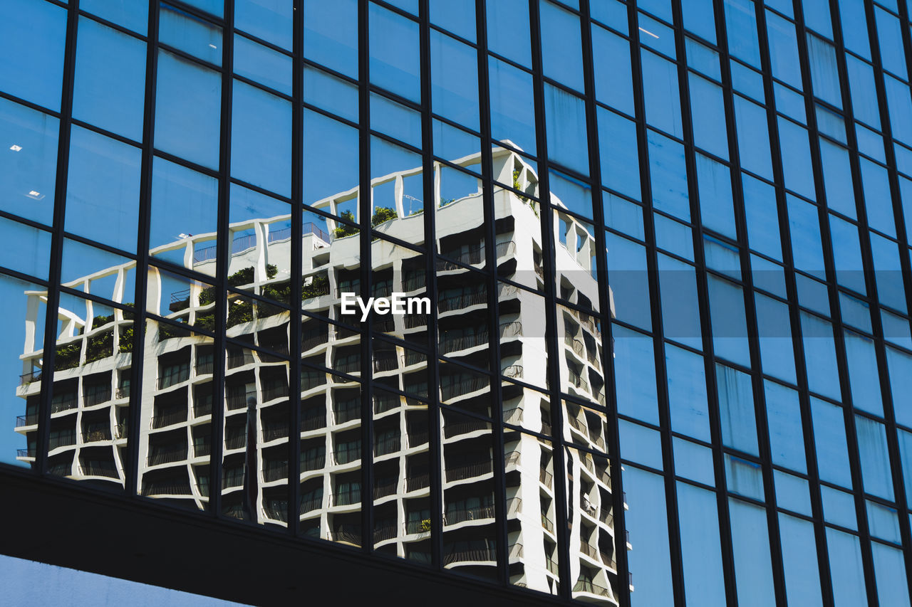 LOW ANGLE VIEW OF GLASS BUILDING AGAINST SKY