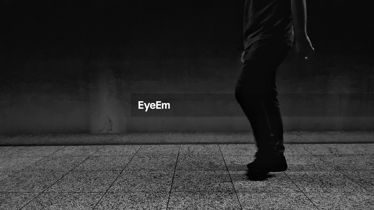 LOW SECTION OF MAN STANDING ON CARPET