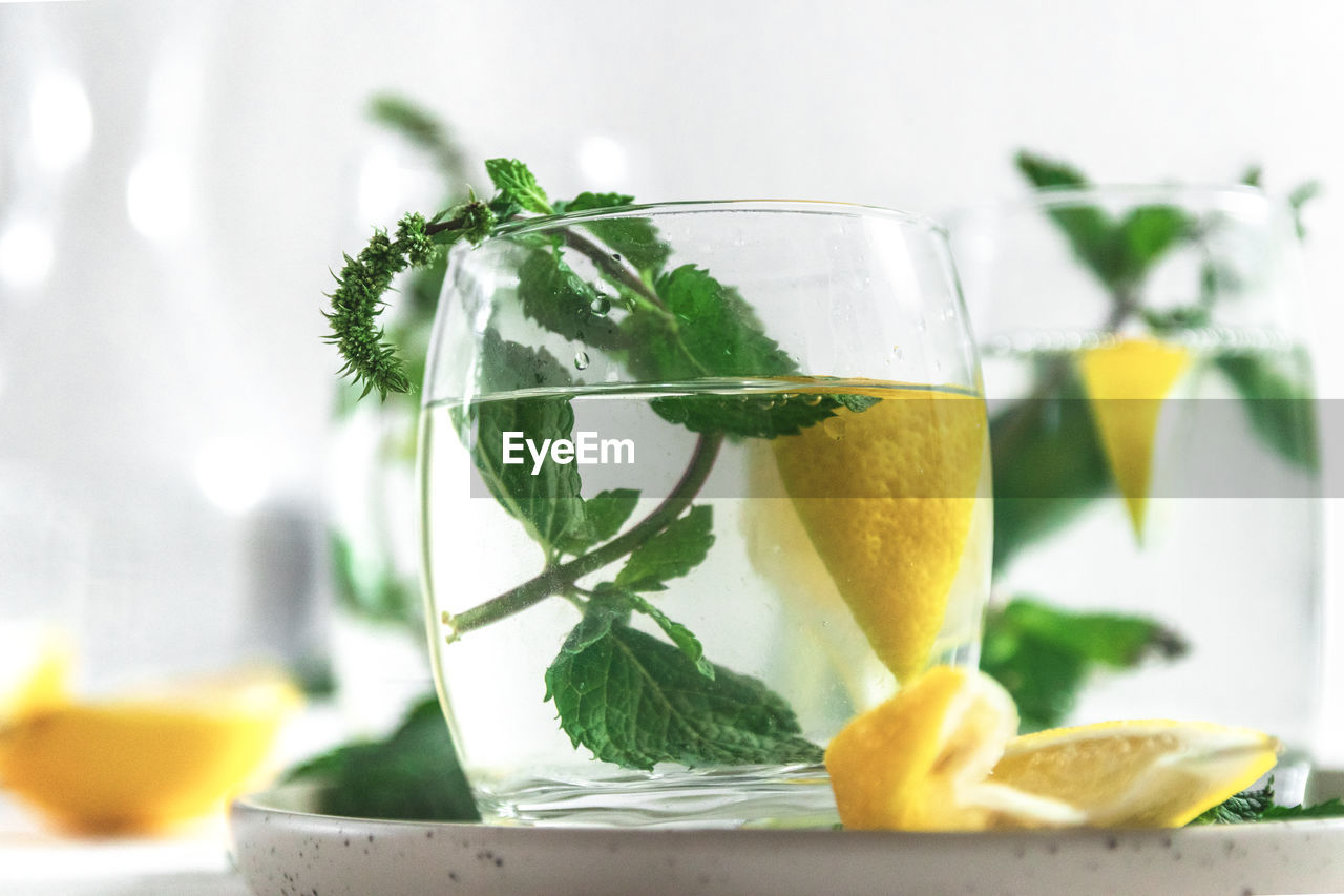 Close-up of glass of mojito on white table