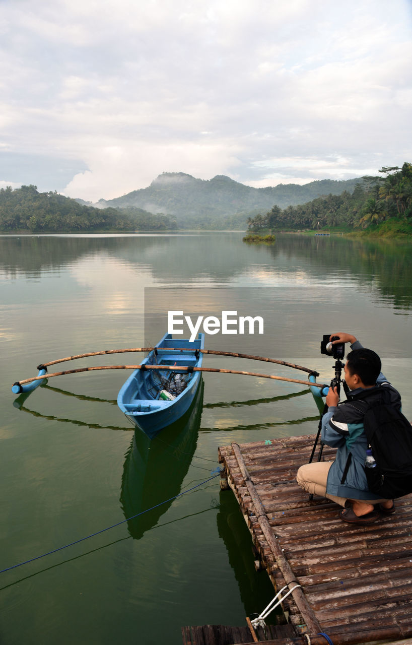 Photographer is aiming for the boat on the lake. sermo reservoir, kulonprogo