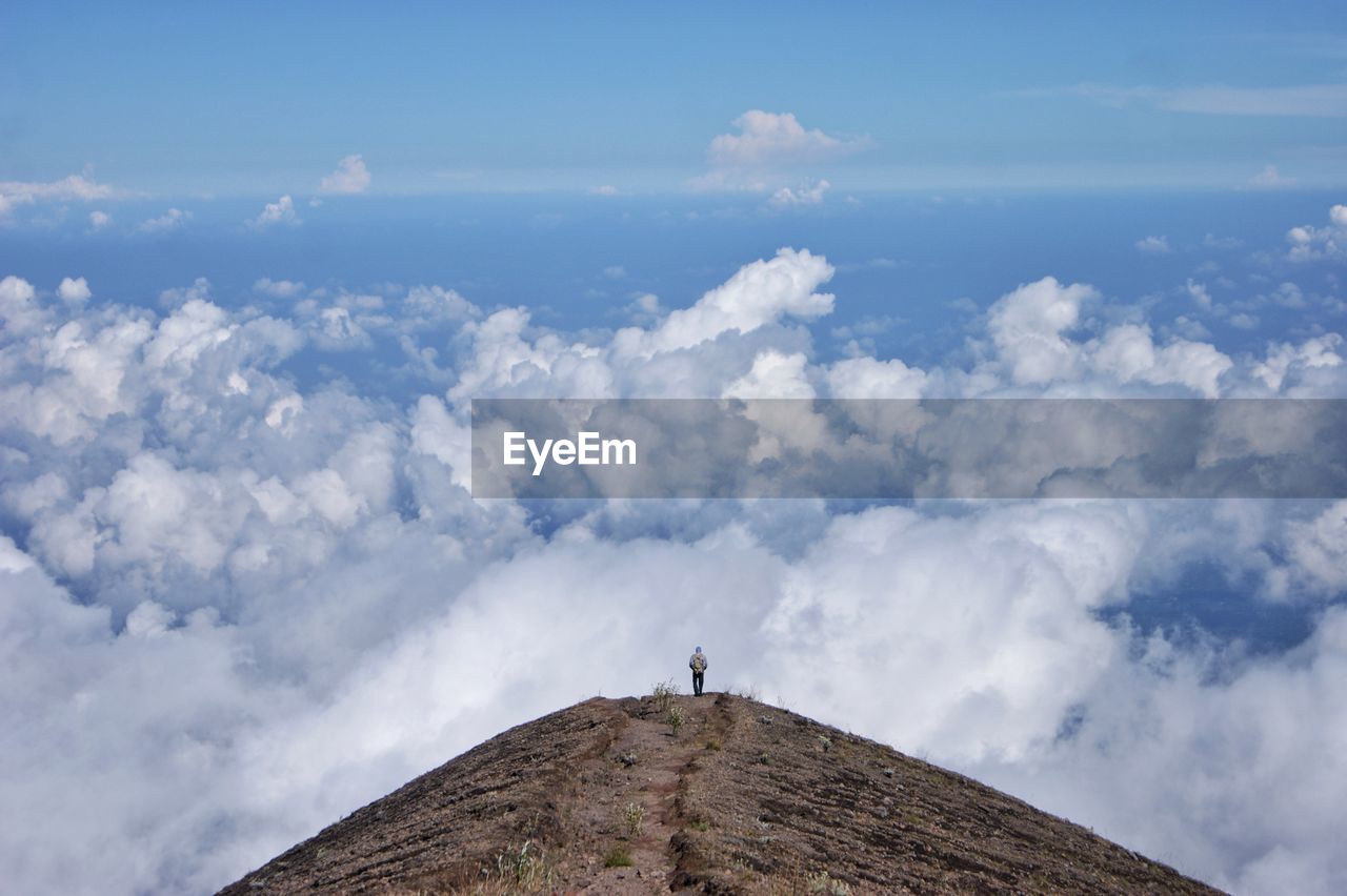 Man standing on mountain against sky