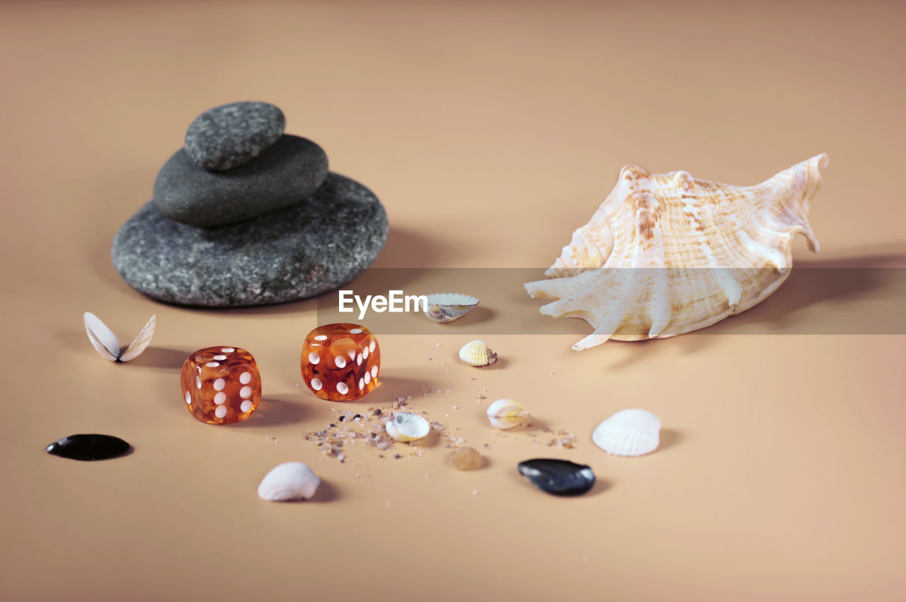 Background of sea stones, small shells and two amber dice