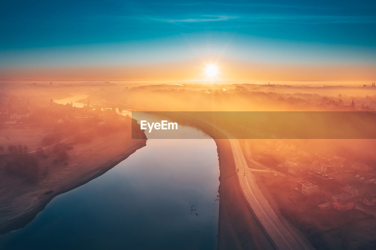 Aerial view of river flowing on landscape during sunrise