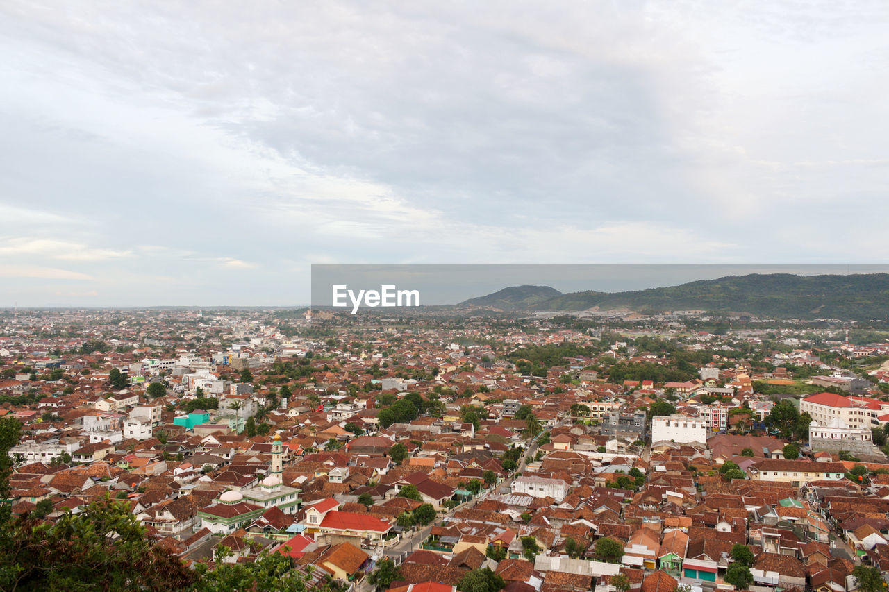 High angle view of crowded bandar lampung city against cloudy sky