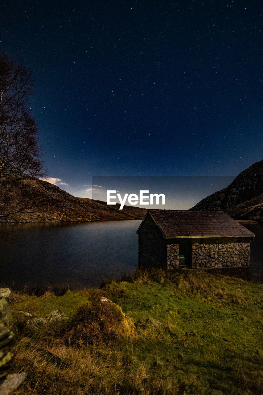 House on field against sky at night