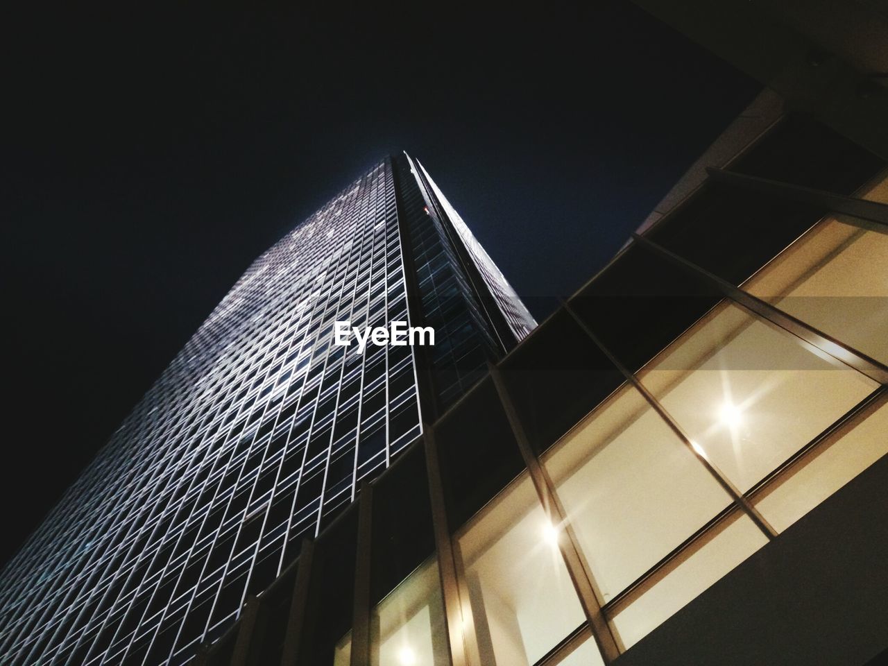 LOW ANGLE VIEW OF ILLUMINATED MODERN BUILDING AGAINST SKY