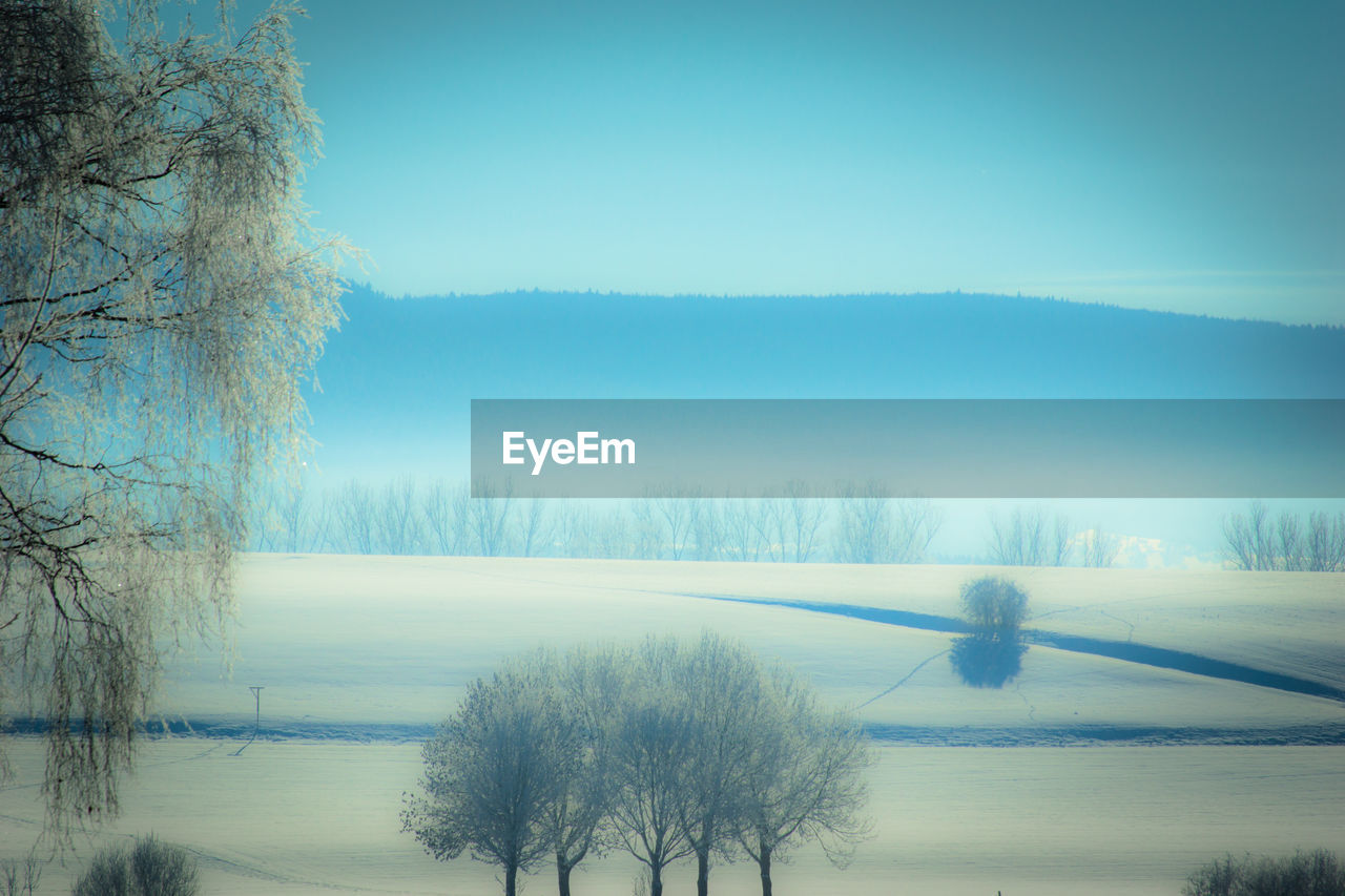 SCENIC VIEW OF FROZEN LAKE AGAINST SKY