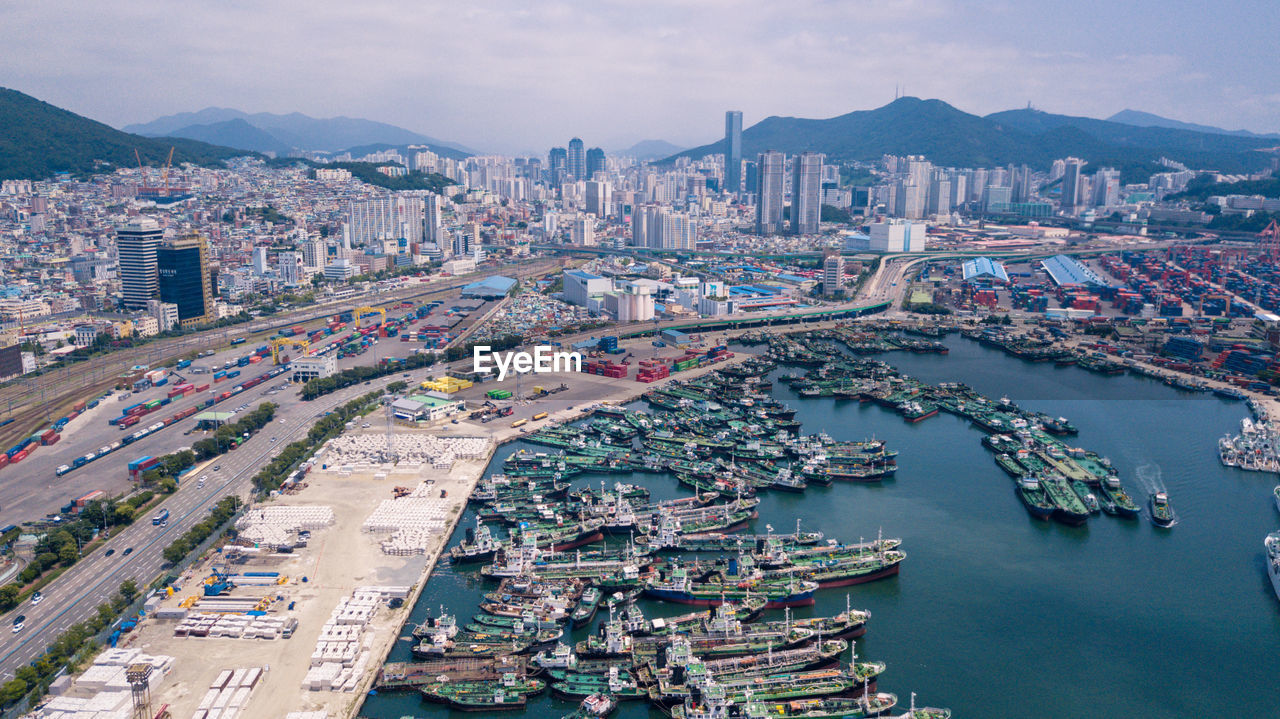 Aerial view of cityscape and mountains against sky