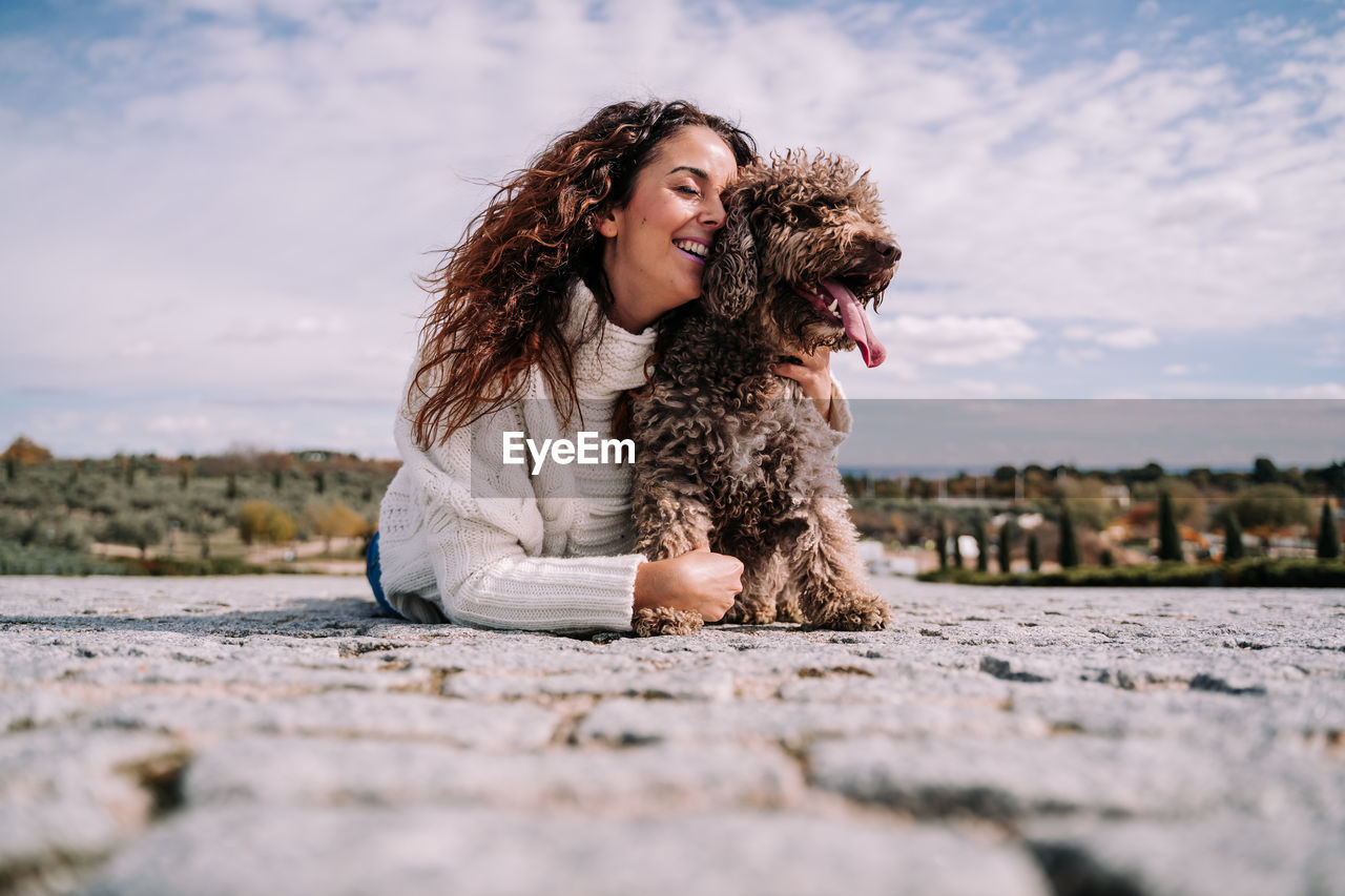 Woman lying down on floor with dog outdoors