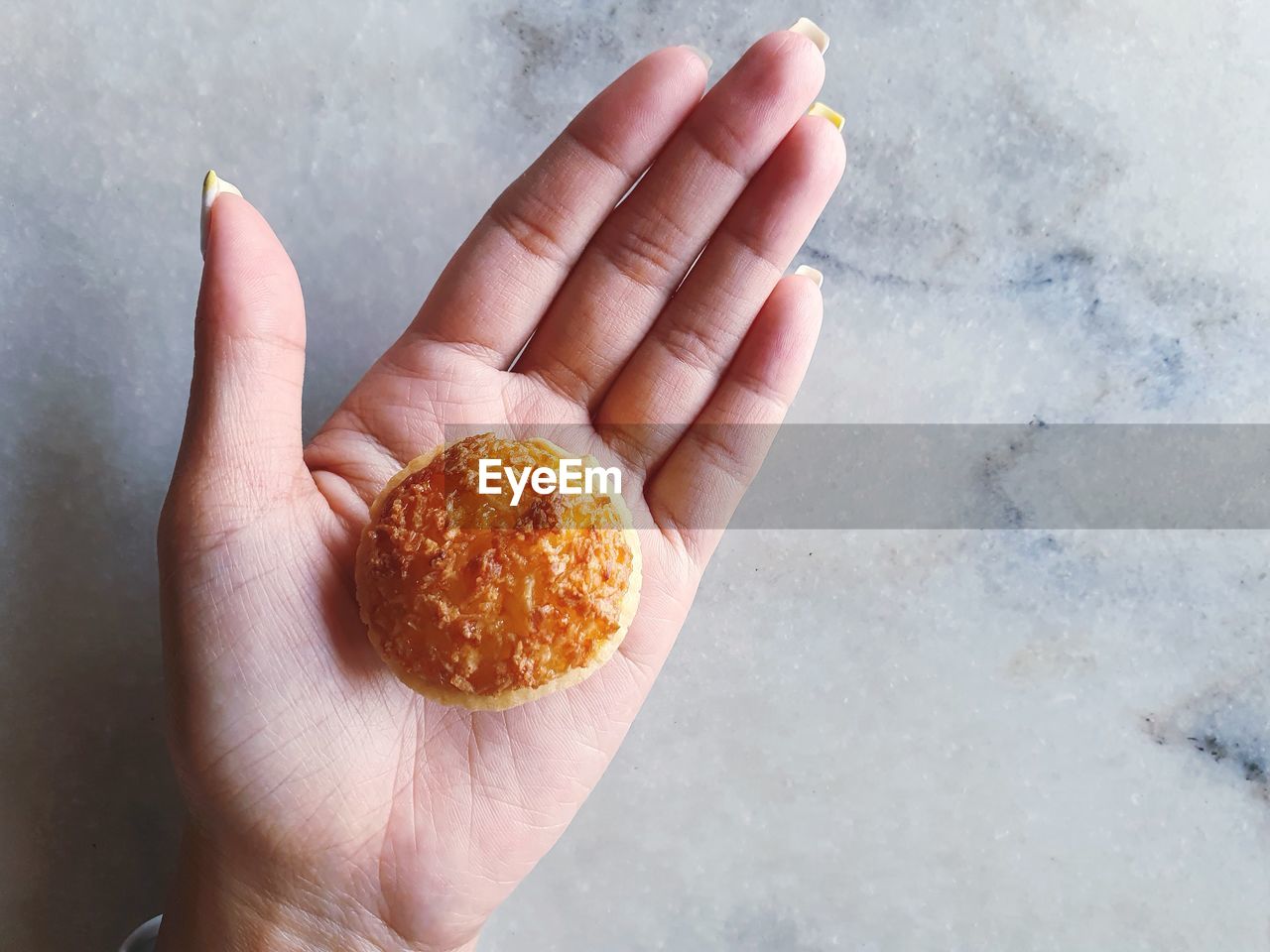 HIGH ANGLE VIEW OF HAND HOLDING ORANGE