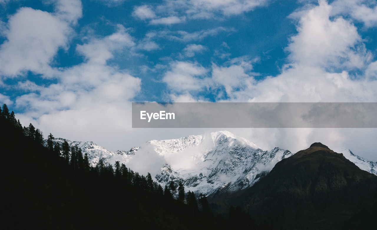 Scenic view of mountains against cloudy sky