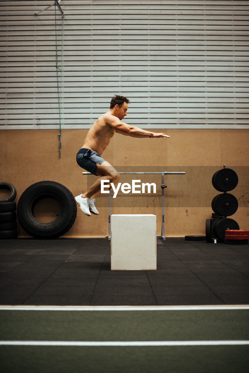 Shirtless man exercising in gym