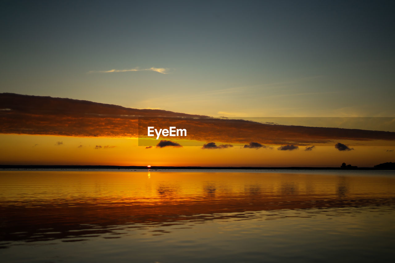 SCENIC VIEW OF SEA AGAINST ORANGE SKY DURING SUNSET