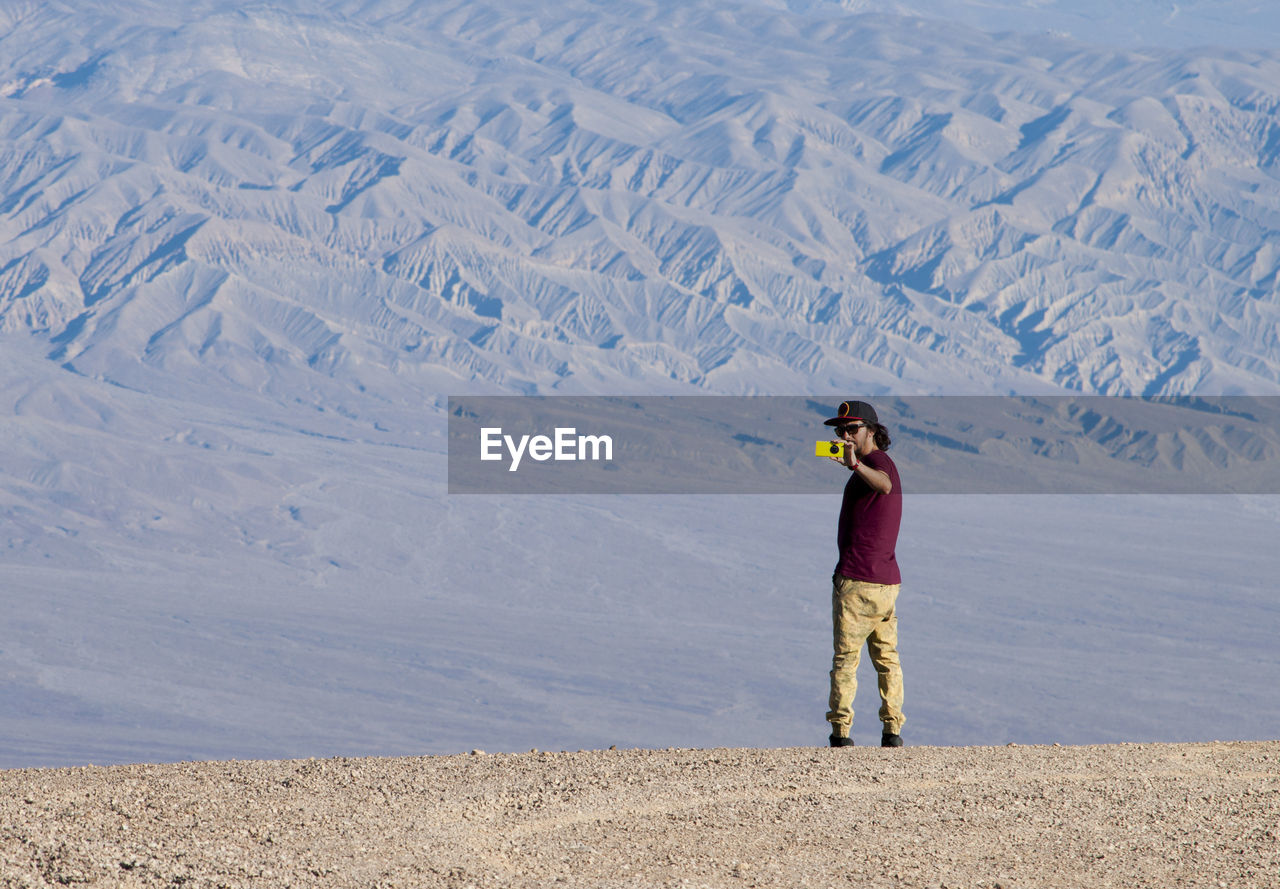 Man photographing on desert landscape
