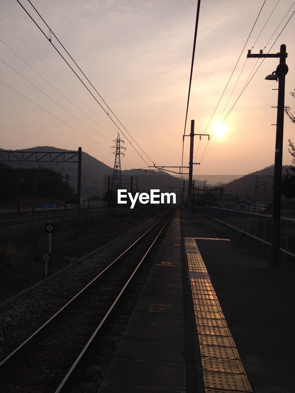 Railroad tracks against sky during sunset