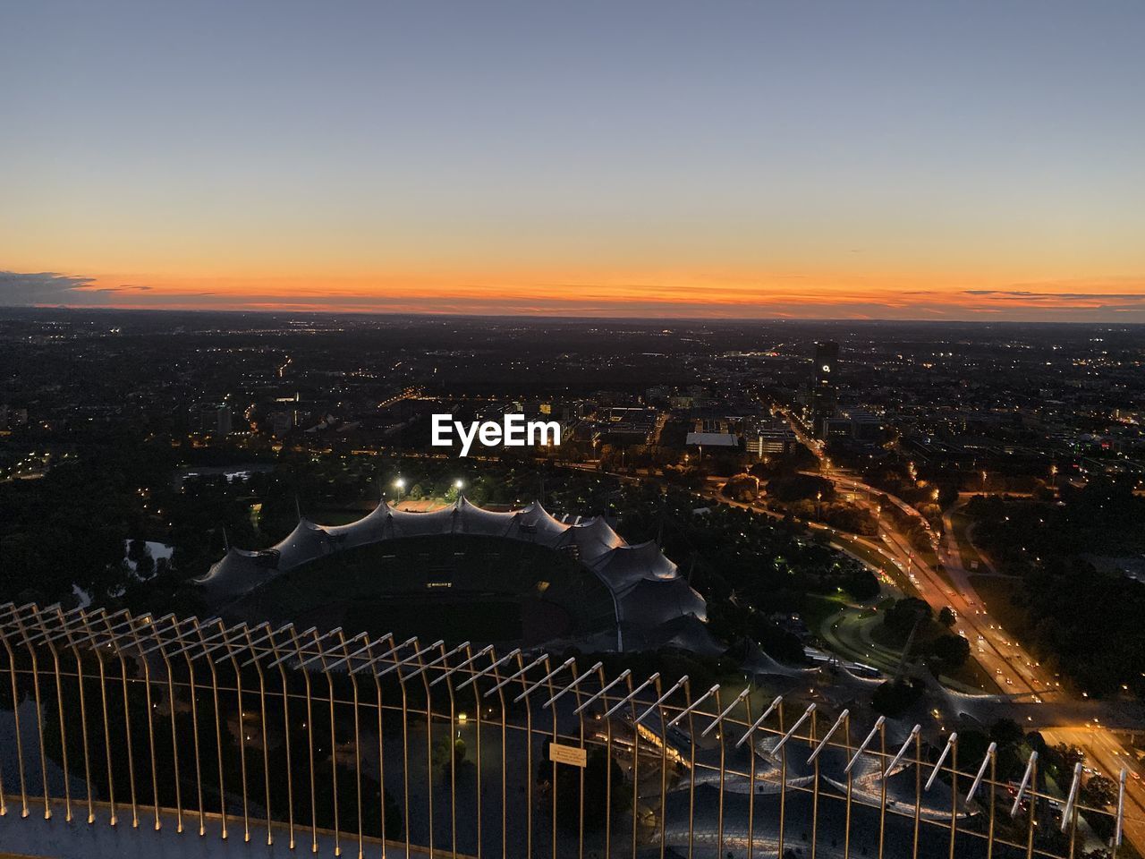 HIGH ANGLE VIEW OF ILLUMINATED CITY BUILDINGS AT NIGHT