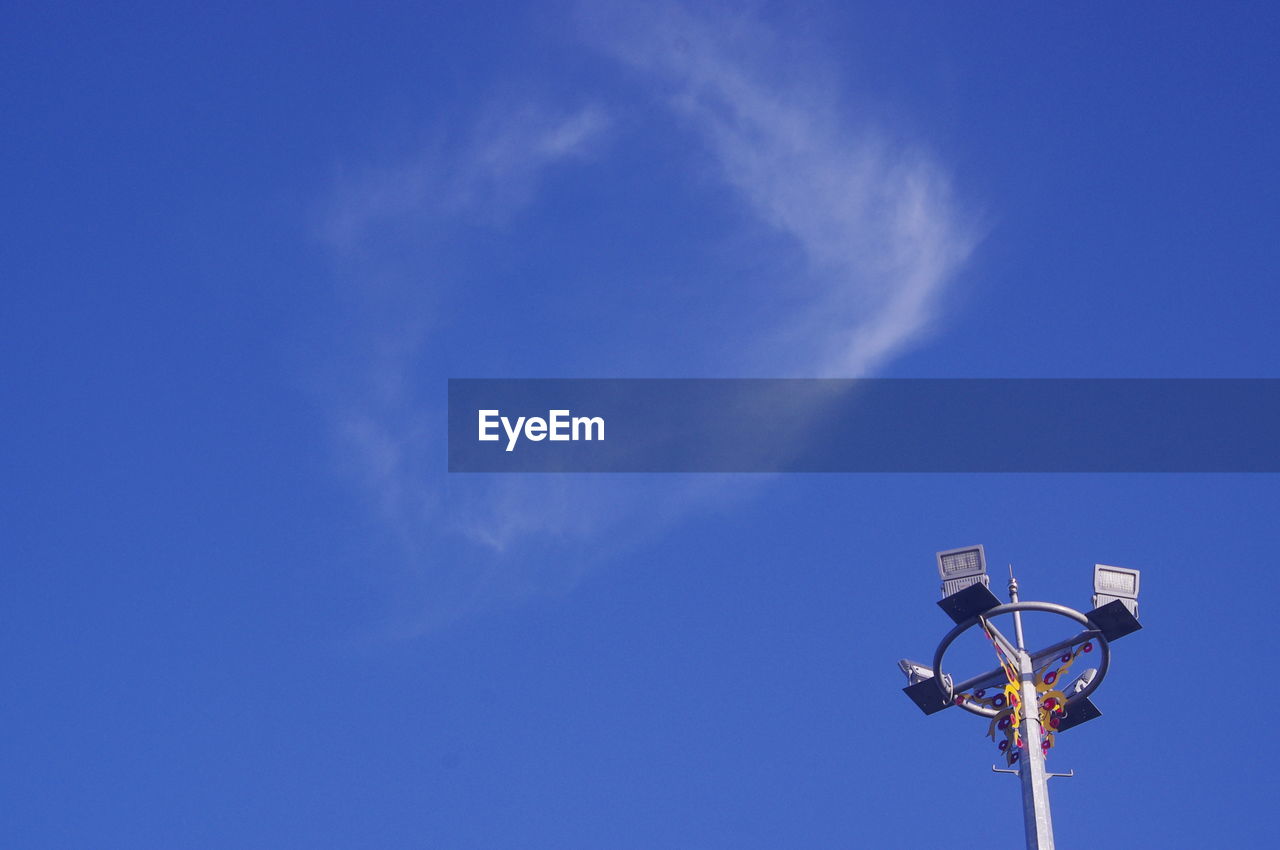 Low angle view of street light against blue sky