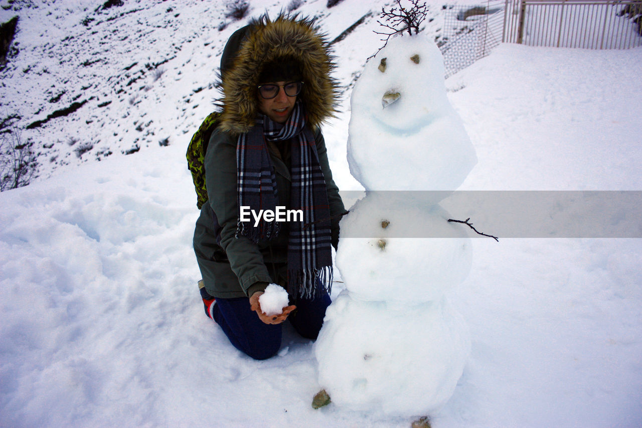 PORTRAIT OF WOMAN WITH SNOW COVERED FIELD