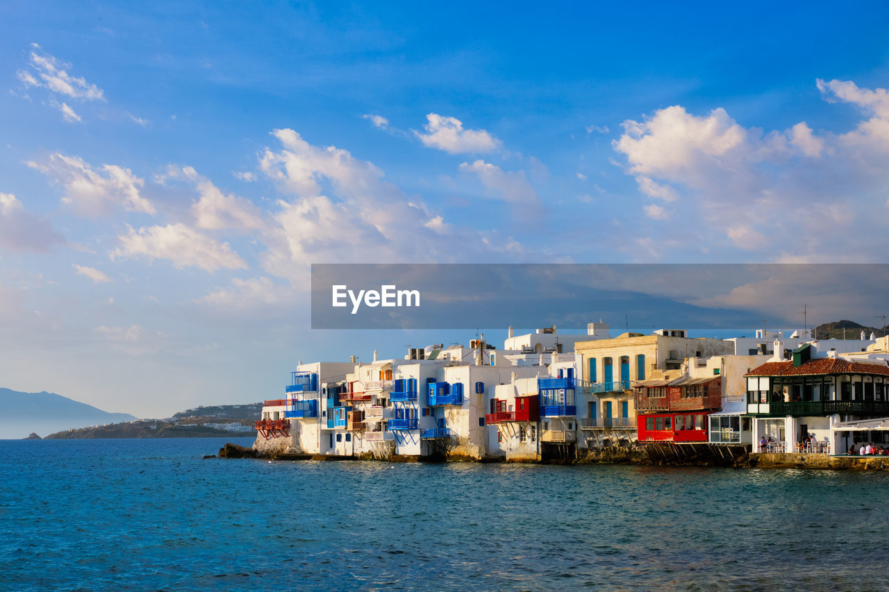 Sunset in mykonos, greece, with cruise ship and yachts in the harbor