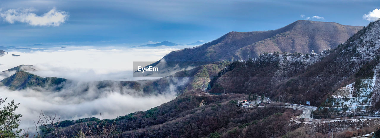 Scenic view of mountain range against cloudy sky