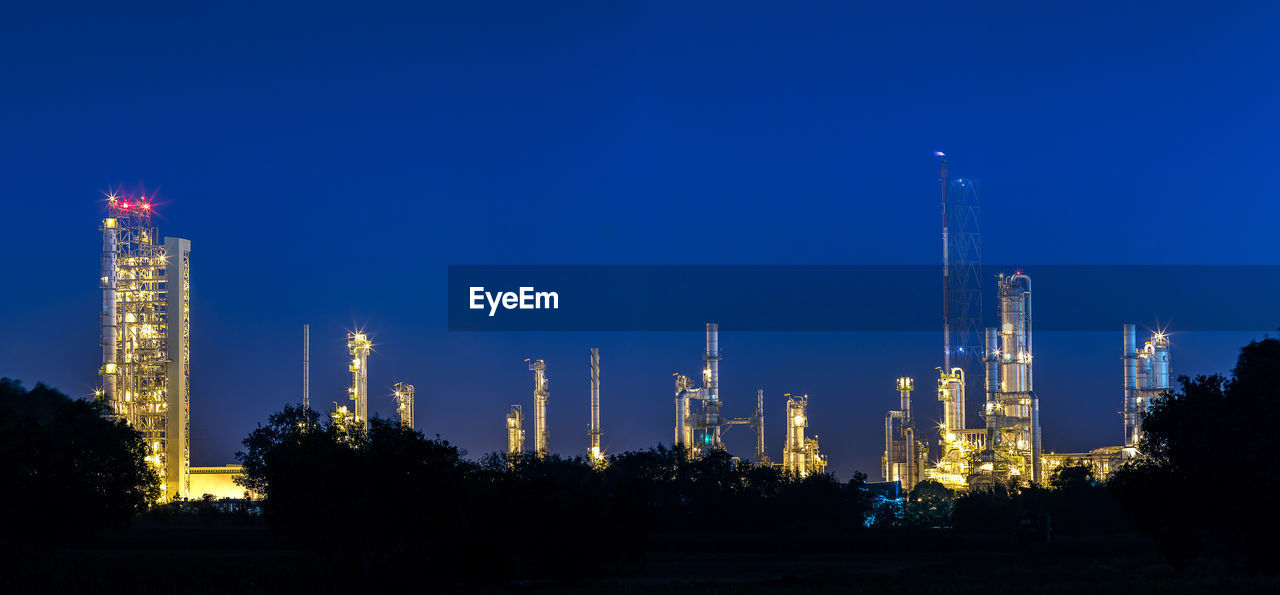 PANORAMIC VIEW OF ILLUMINATED BUILDING AGAINST CLEAR SKY AT NIGHT