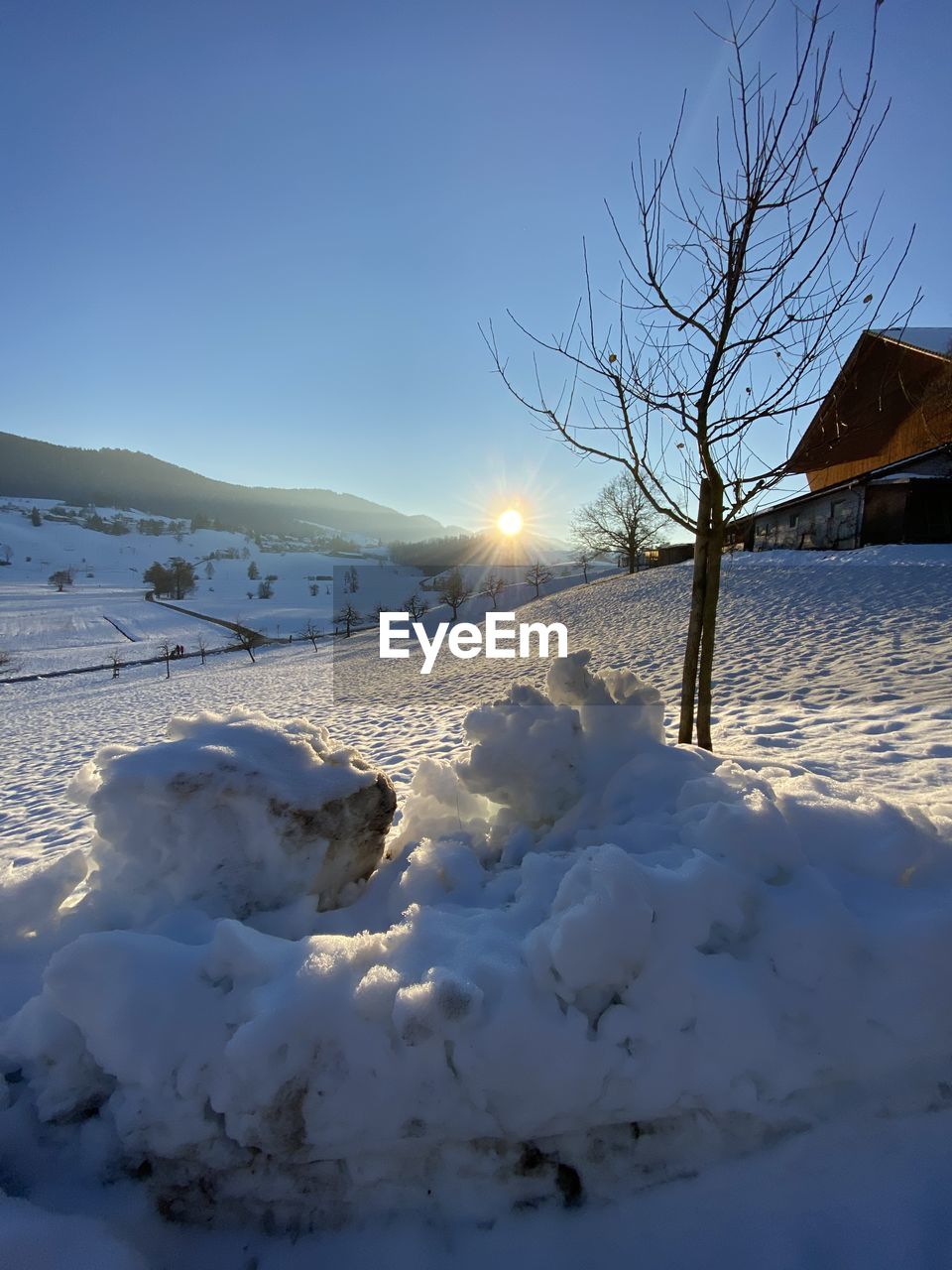 winter, snow, cold temperature, nature, blue, freezing, sky, reflection, ice, sunlight, frozen, light, tree, no people, beauty in nature, environment, low angle view, scenics - nature, outdoors, plant, illuminated, tranquility, landscape, white, day, sun, mountain, land