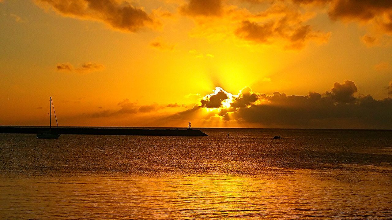 Sailboat in sea at sunset