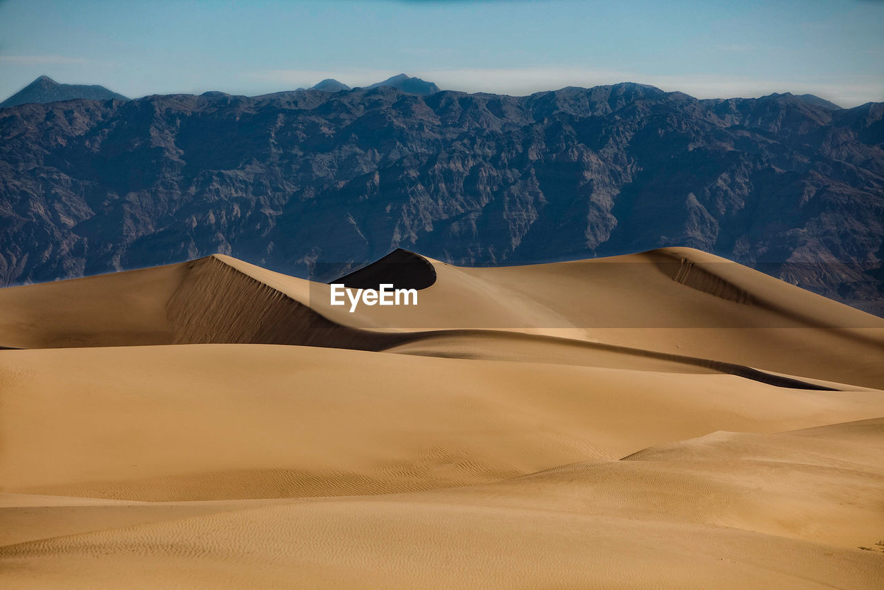 Sand dune in desert against clear sky