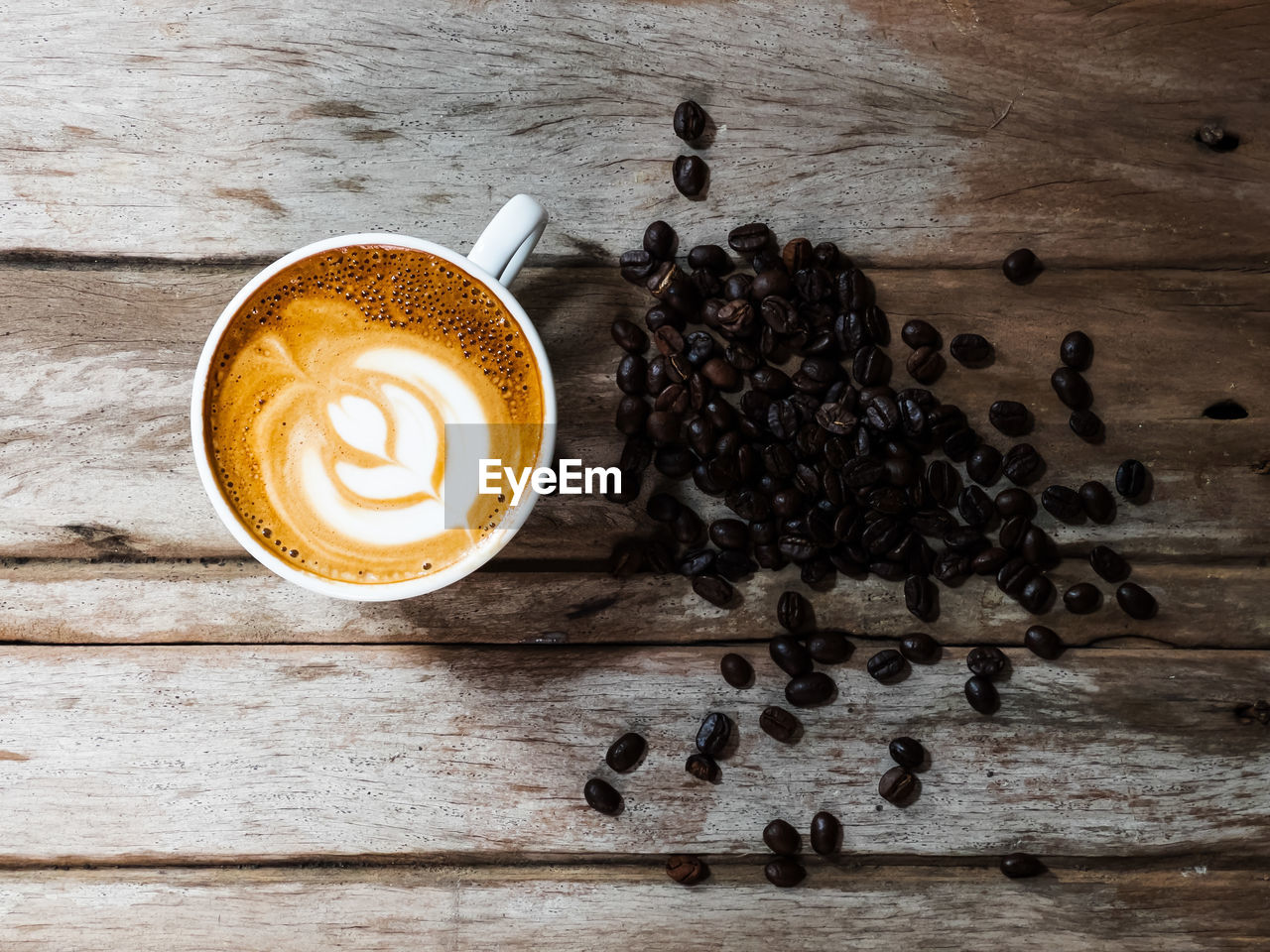 HIGH ANGLE VIEW OF COFFEE CUP ON WOODEN TABLE