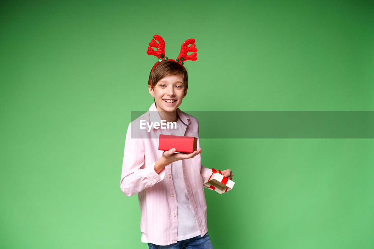 Happy child with new year gift on green studio background, copy space. excited