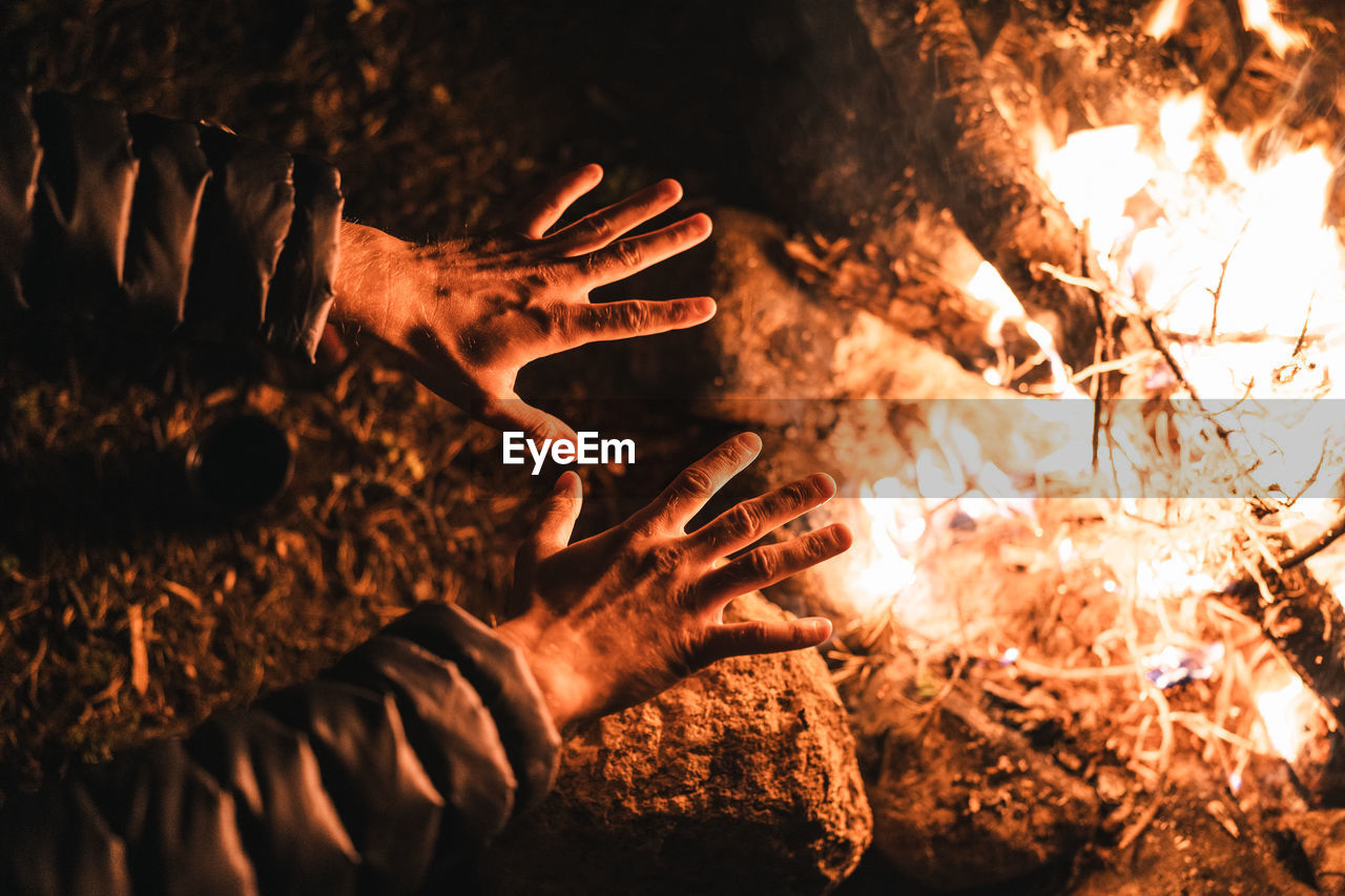 Person warming hands over bonfire