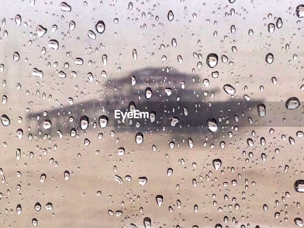 Close-up of waterdrops on glass against blurred background