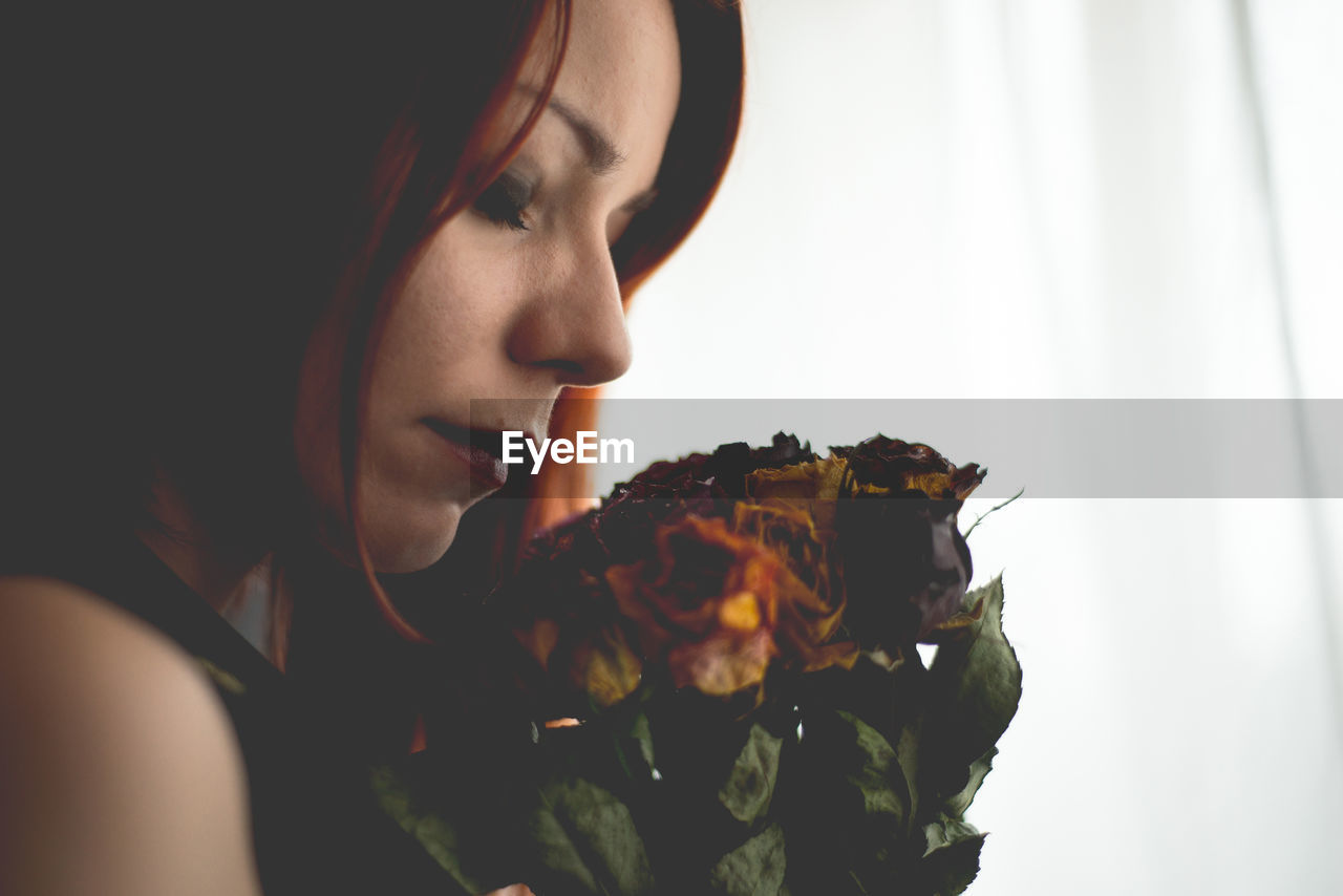 Close-up of woman holding dead flowers