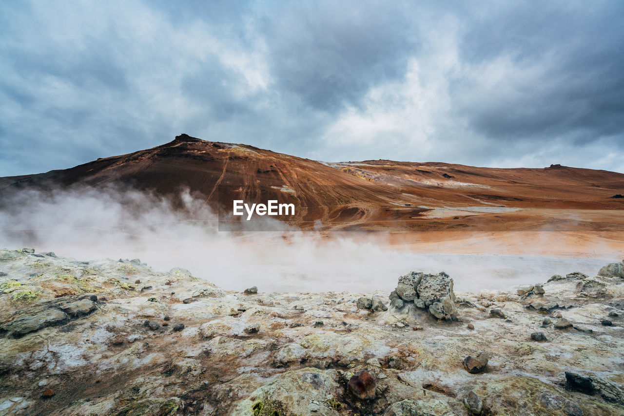 Scenic view of geyser at volcanic crater against sky