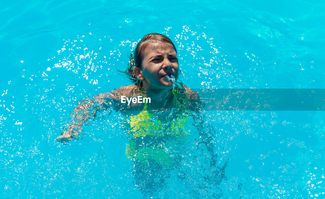 portrait of young woman swimming in pool