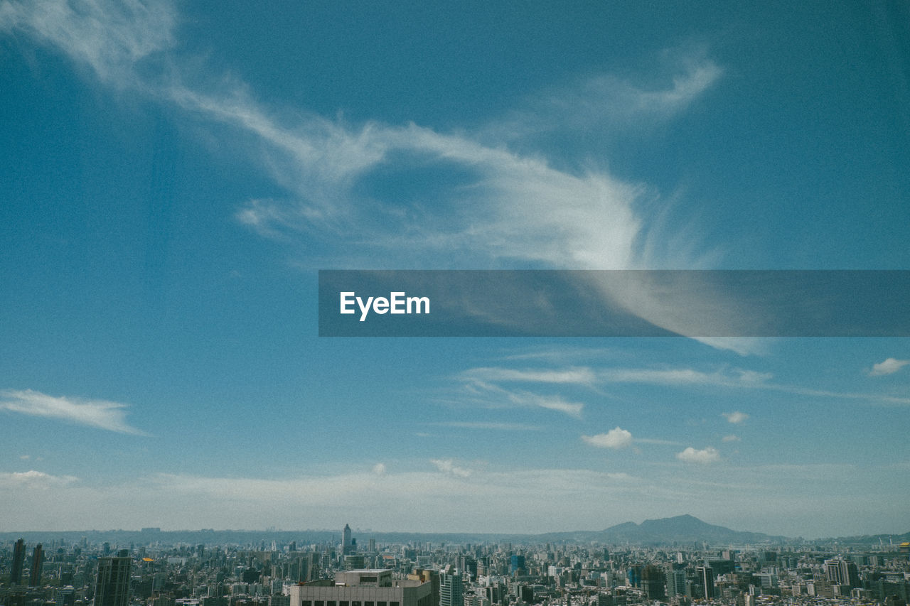 Aerial view of buildings in city against sky