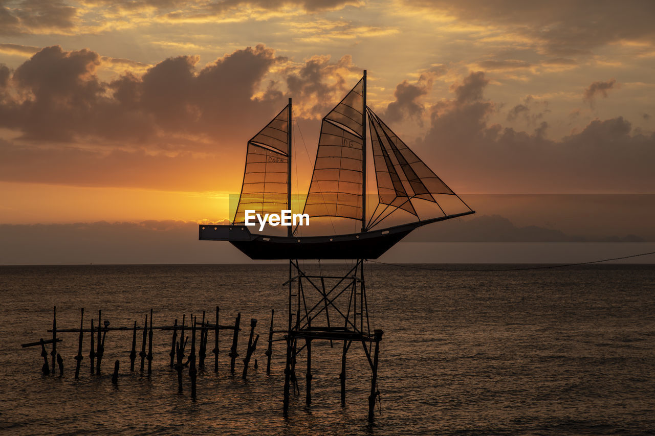 SILHOUETTE SAILBOAT ON SEA AGAINST SKY DURING SUNSET