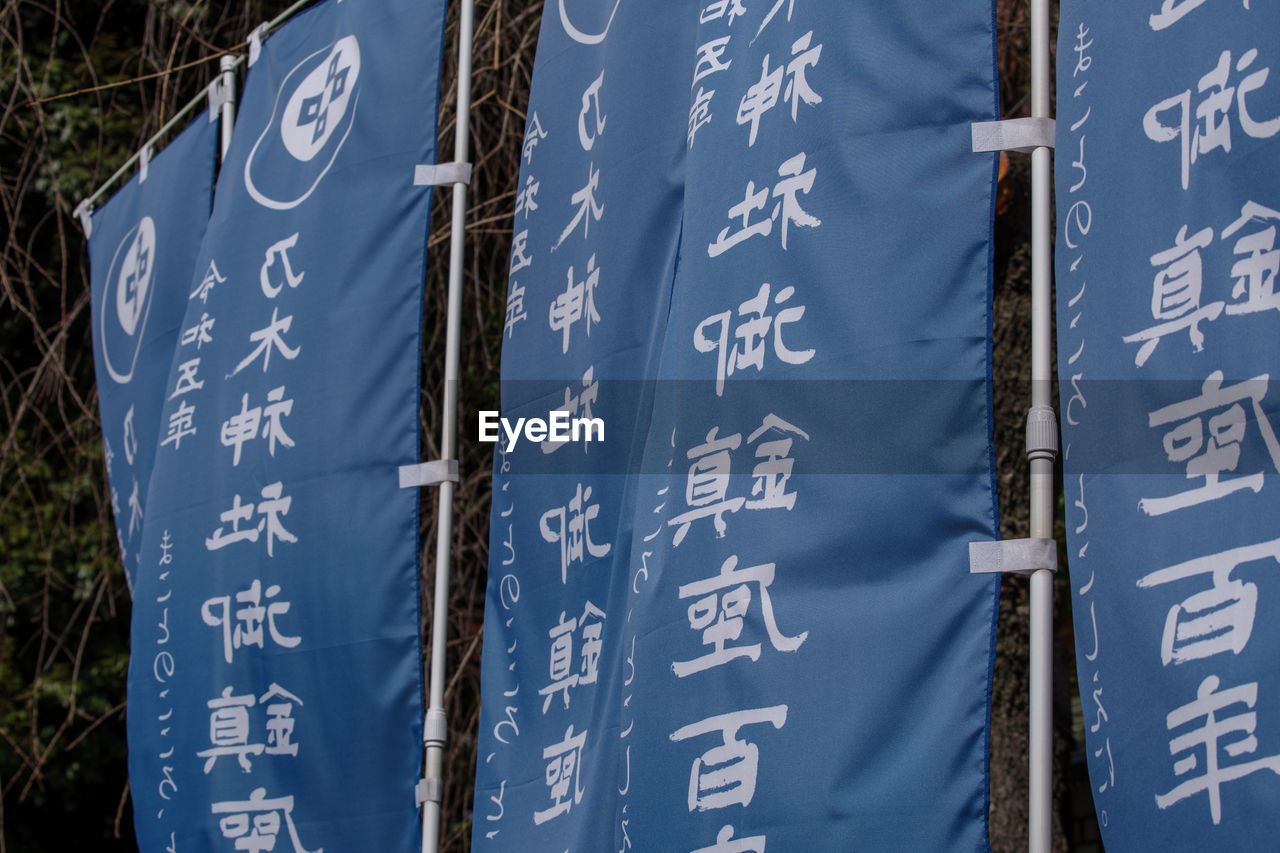 text, blue, communication, no people, banner, day, sign, tree, number, western script, outdoors