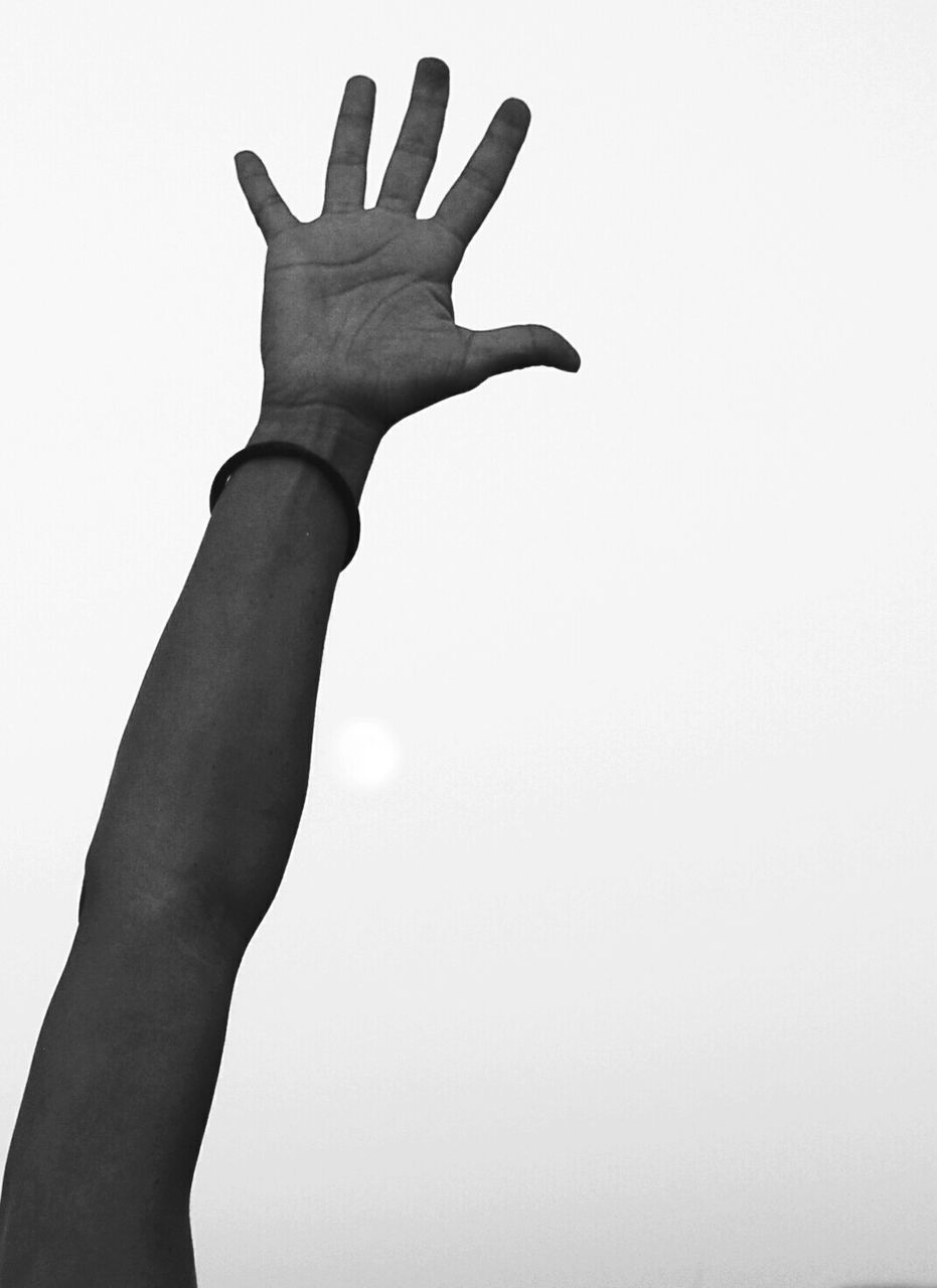 Cropped image of hand against clear sky