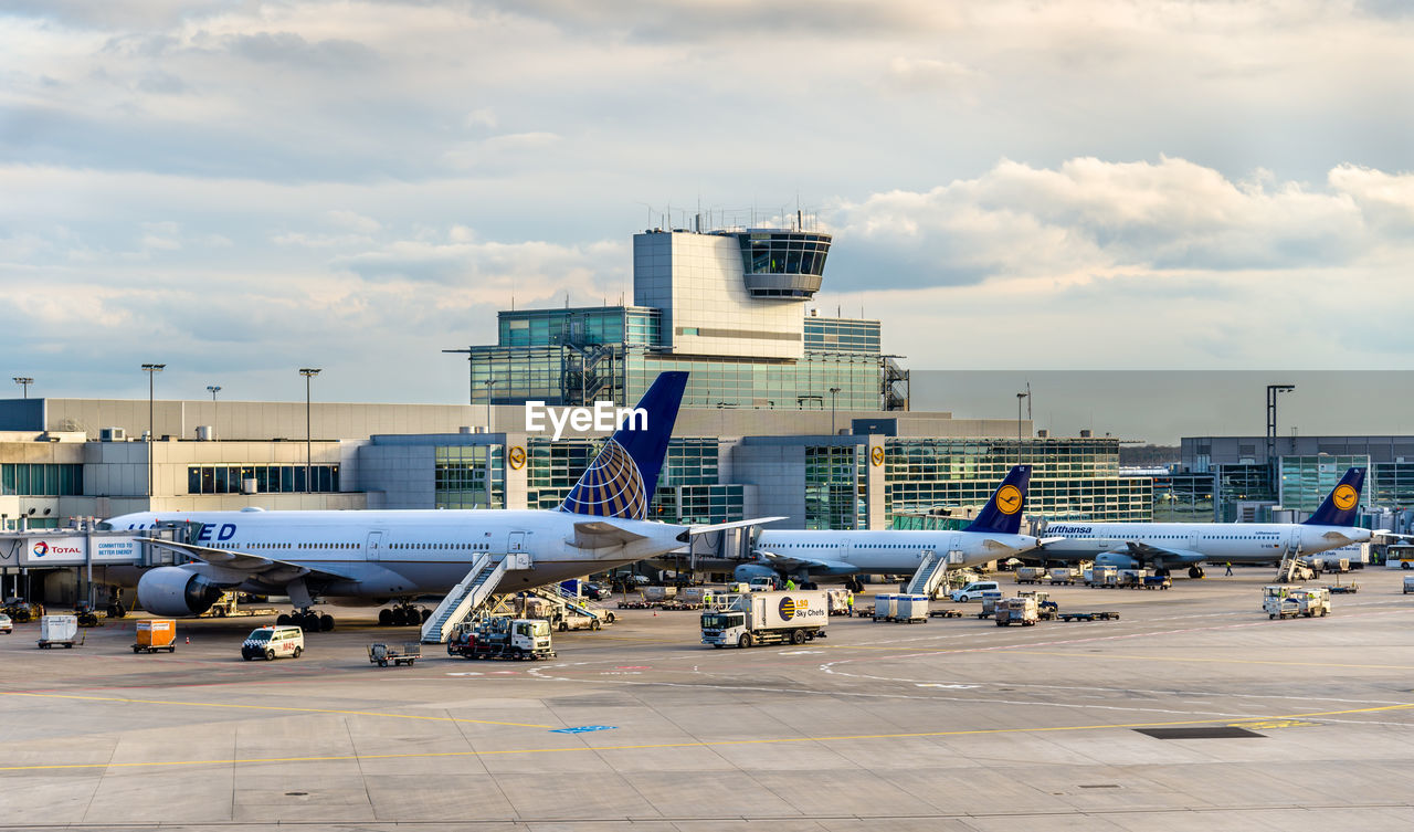 AIRPLANE AT AIRPORT RUNWAY AGAINST SKY