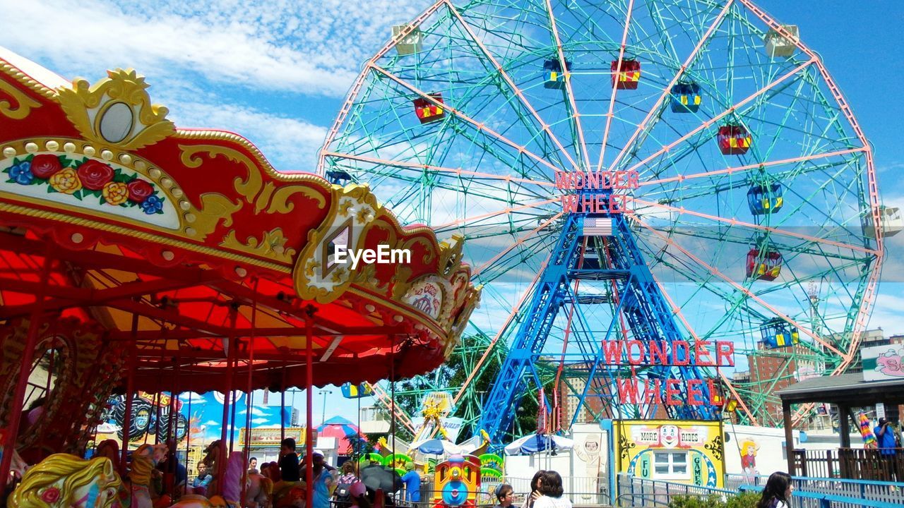 LOW ANGLE VIEW OF FERRIS WHEEL IN AMUSEMENT PARK