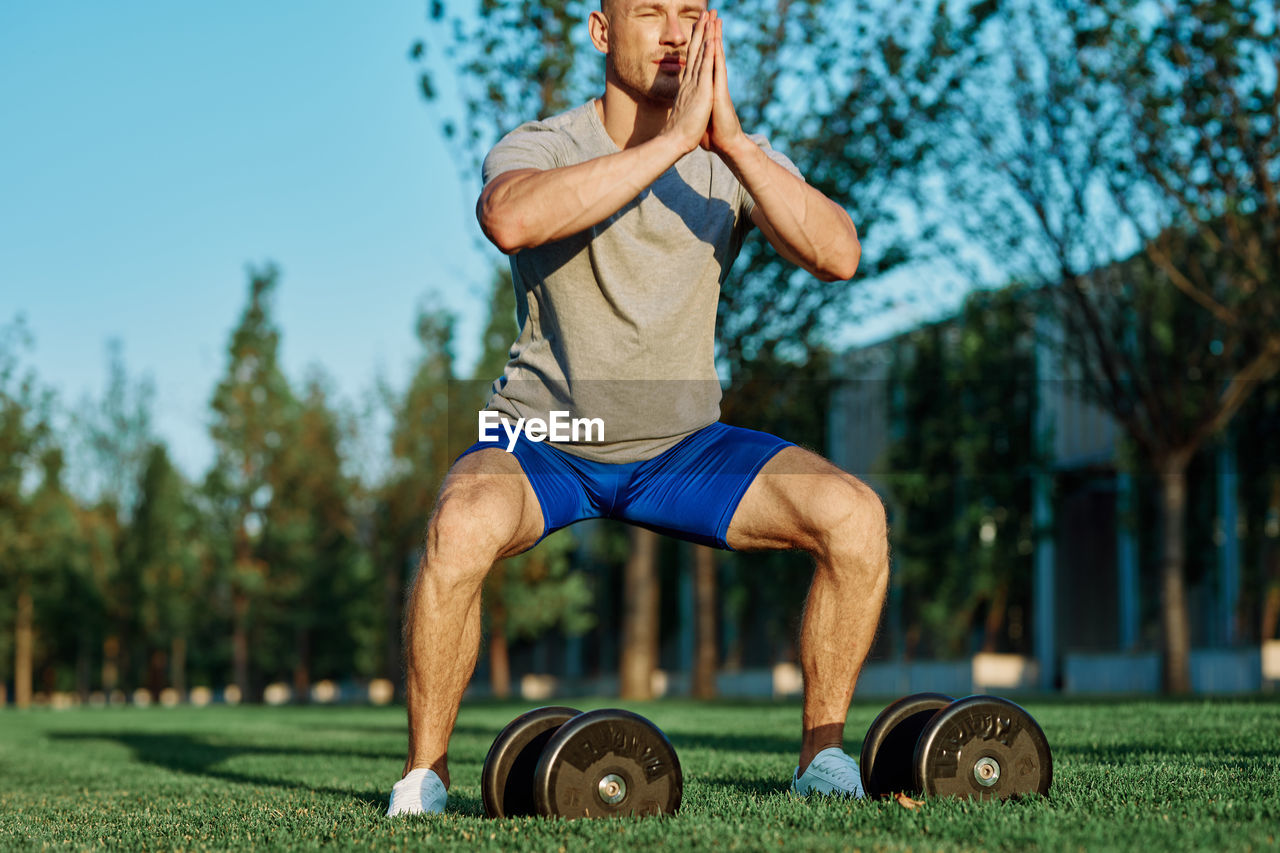 Full length of man wearing hat while sitting on grass