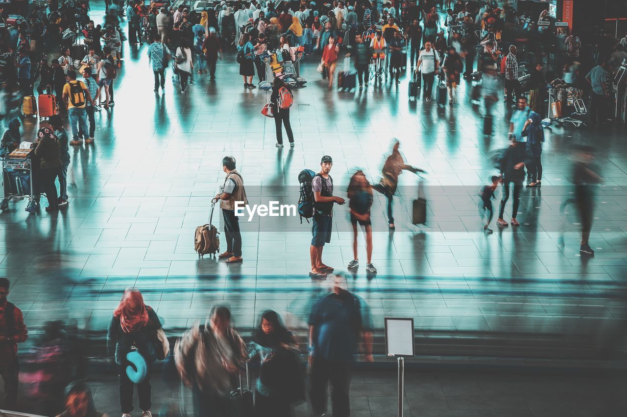 HIGH ANGLE VIEW OF PEOPLE WALKING ON ROAD