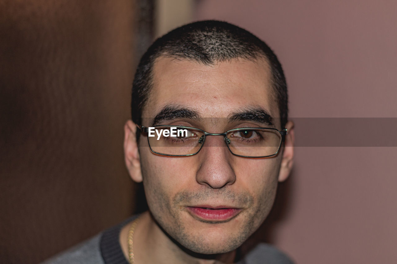 CLOSE-UP PORTRAIT OF YOUNG MAN WITH EYEGLASSES