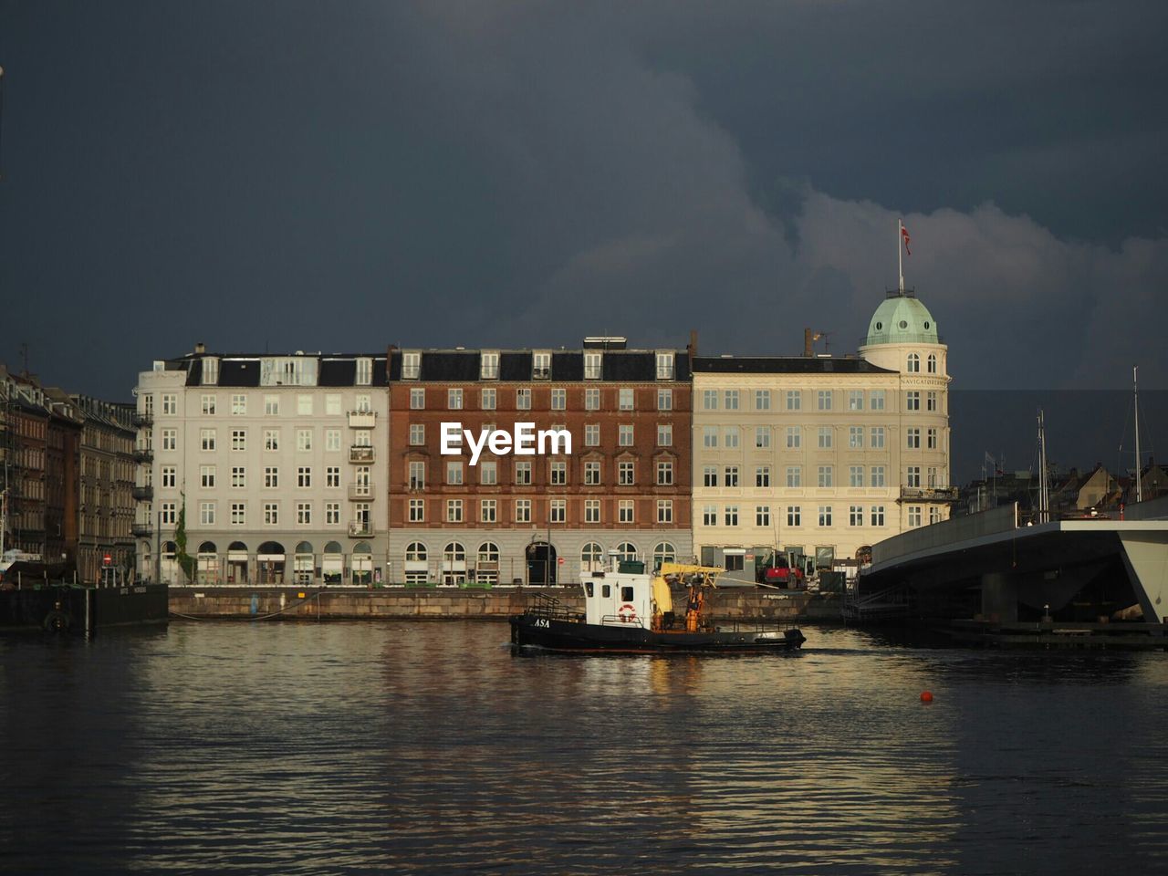 River by building against cloudy sky