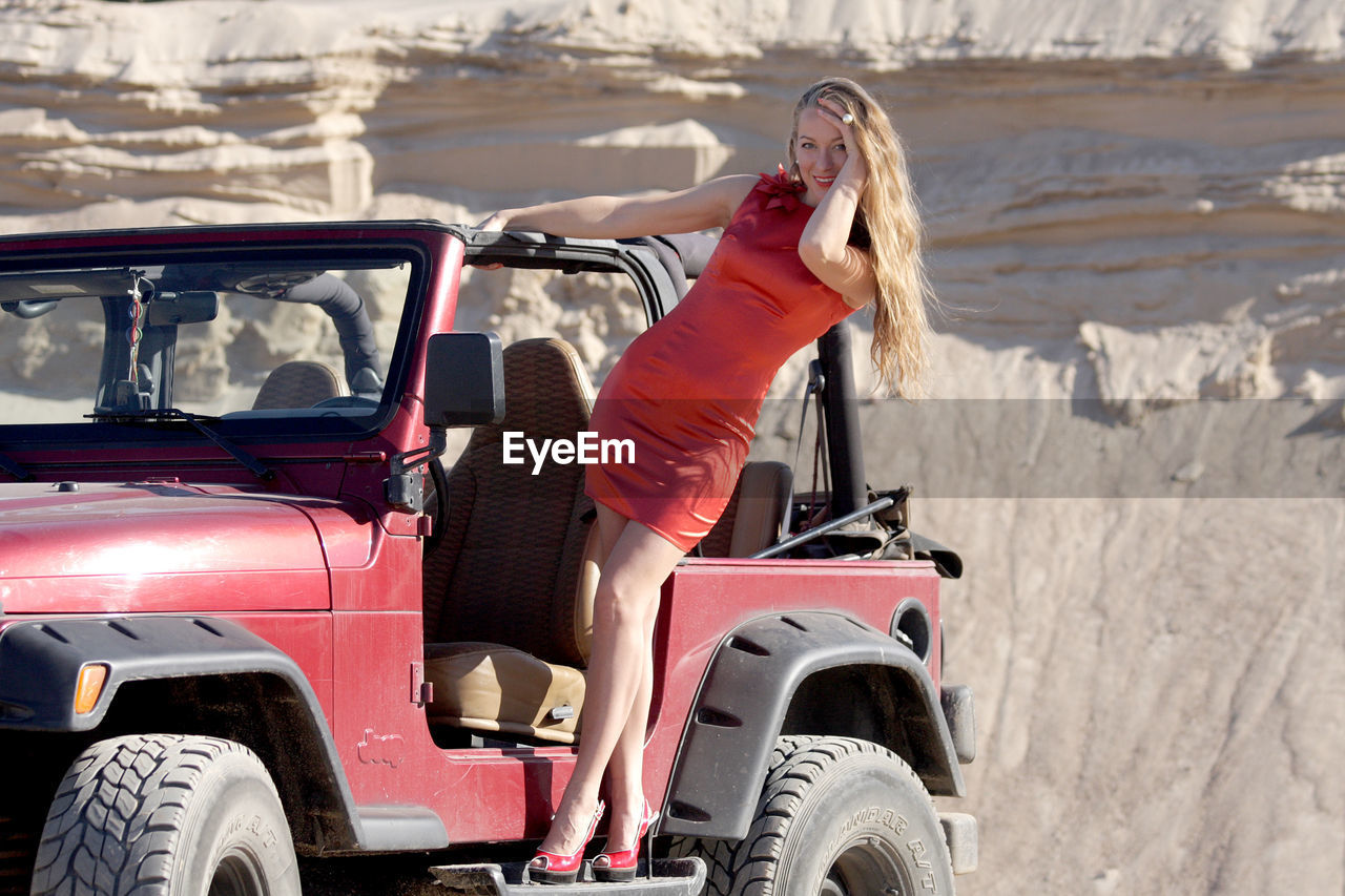 Portrait of woman standing on jeep